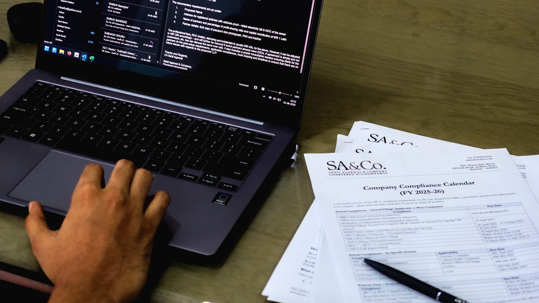 A compliance calendar and laptop on the desk